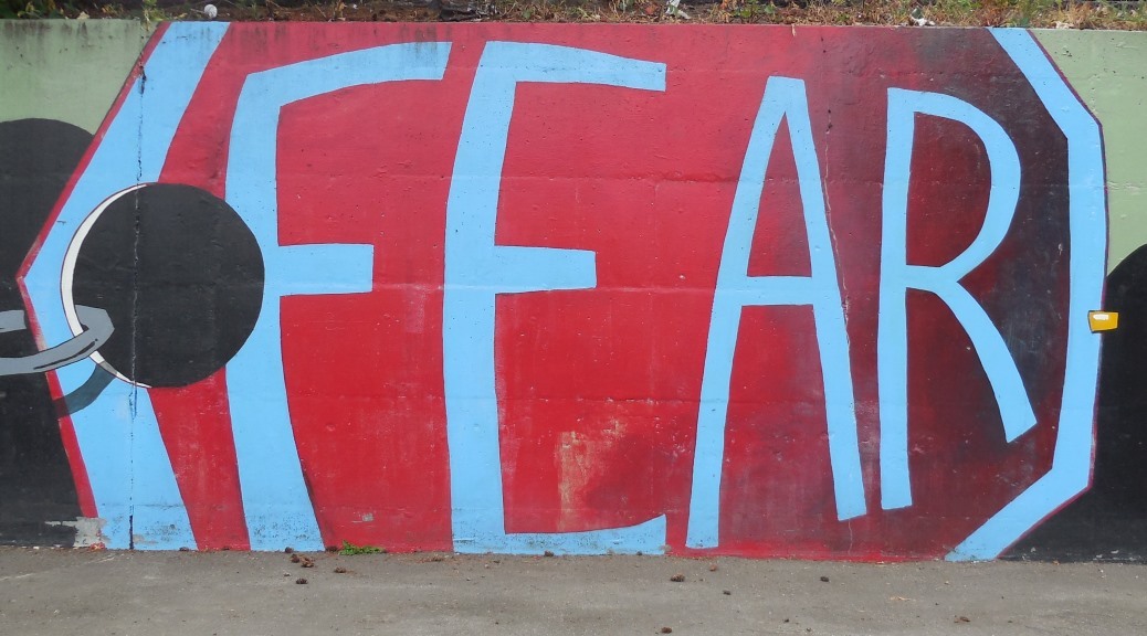 The word "fear" painted on a concrete wall near an elementary school.